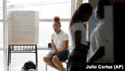 Tinazsha Johnson, 15, waits to talk about her project during the science fair a New Song Community Learning Center in Baltimore. Where she learned to cope with stress and sorrow.