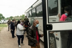 Asylum-seeking migrants from Venezuela board a U.S. Border Patrol's bus to be transported after crossing the Rio Grande River into the United States from Mexico in Del Rio, Texas, May 27, 2021.