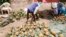 FILE - A vendor displays pineapples while waiting for costumers at an informal market on the road opposite to Del Monte's pineapple plantations in Kabati, Kenya on January 18, 2024.