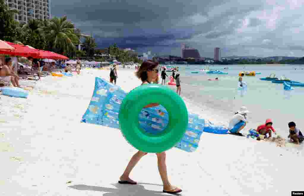 นักท่องเที่ยวยังคงเล่นน้ำอย่างมีความสุข ที่ Tumon beach บนเกาะกวม ของสหรัฐฯ แม้เกาหลีเหนือข่มขู่จะยิงขีปนาวุธ 4 ลูกมายังพื้นที่ดังกล่าว หลังสงครามน้ำลายอันดุเดือดระหว่างผู้นำสหรัฐฯและเกาหลีเหนือตลอดทั้งสัปดาห์