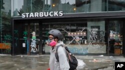 10月6日一名蒙面人行經被破壞的星巴克咖啡店前。