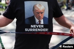 FILE - A supporter of former President Trump holds a MAGA dog leash on the first day of the trial of Trump and others in a civil fraud case by state Attorney General Letitia James, outside the Manhattan courthouse in New York City, October 2, 2023.