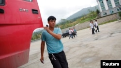 FILE - A Chinese truck driver arrives at customs at the border between China and North Korea near Hunchun, Jilin province, Aug. 29, 2011. 