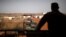 FILE - A French soldier is silhouetted as he looks out over military vehicles in Gao, Mali, Aug. 1, 2019. 