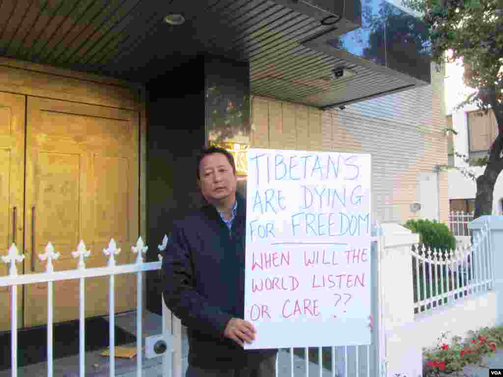 西藏人多吉带着家人一起撕毛像(美国之音 容易拍摄)