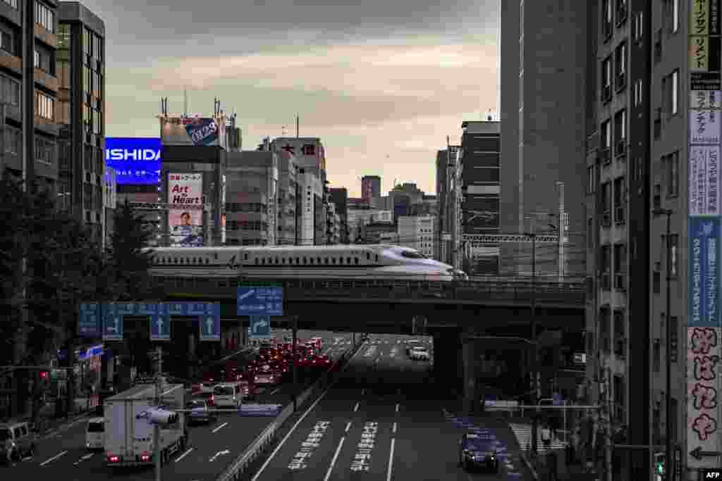 Šinkansen, brzi voz putuje kroz poslovni deo Tokija u Japanu. 20. juli, 2021. ( Foto: Filip Fong / AFP )