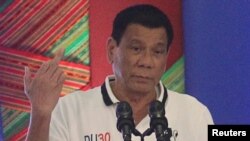 Presiden Filipina Rodrigo Duterte mengacungkan jari tengah saat berbicara di depan para pejabat pemerintah di kota Davao, Filipina selatan (20/9). (Reuters/Lean Daval Jr)