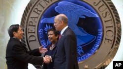 Attorney General Loretta Lynch, center, and Homeland Security Secretary Jeh Johnson, right, welcome Chinese Minister of Public Security Guo Shengkun to the Justice Department in Washington, Tuesday, Dec. 1, 2015.