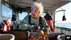 Virginia Oliver (101 tahun), mengukur dan mengikat lobster di kapal putranya Max Oliver, 31 Agustus 2021, di lepas pantai Rockland, Maine. (AP Photo/Robert F. Bukaty)