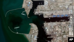 In this June 8, 2020 satellite photo provided by Maxar Technologies, a fake aircraft carrier is seen off the coast of Bandar Abbas, Iran. 