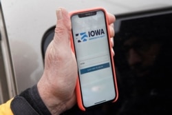 Precinct captain Carl Voss of Des Moines displays the Iowa Democratic Party caucus reporting app on his phone outside of the Iowa Democratic Party headquarters in Des Moines, Iowa, Feb. 4, 2020.