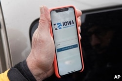 Precinct captain Carl Voss of Des Moines displays the Iowa Democratic Party caucus reporting app on his phone outside of the Iowa Democratic Party headquarters in Des Moines, Iowa, Feb. 4, 2020.