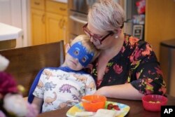 FILE—Miles, the little brother of Tyler Thompson, sits with his mother Miranda Thompson during an interview May 30, 2024, in West Jordan, Utah.