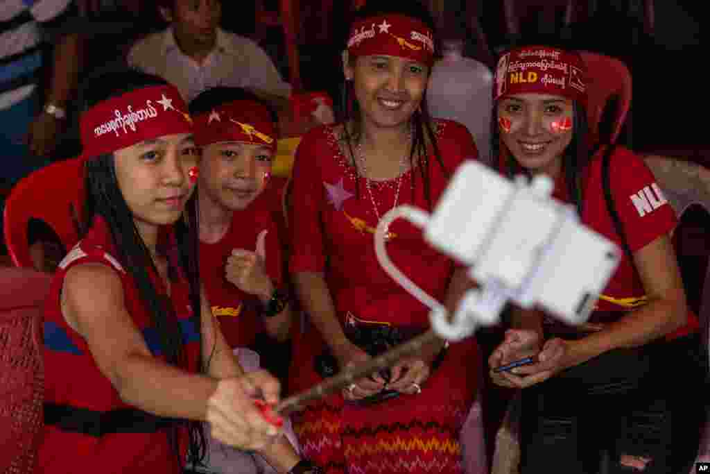 A group of opposition supporters take a selfie as hundreds of people gather outside the opposition party headquarters despite falling rain in Yangon, Myanmar.