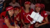 A group of opposition supporters take a selfie as hundreds of people gather outside the opposition party headquarters despite falling rain in Yangon, Myanmar.