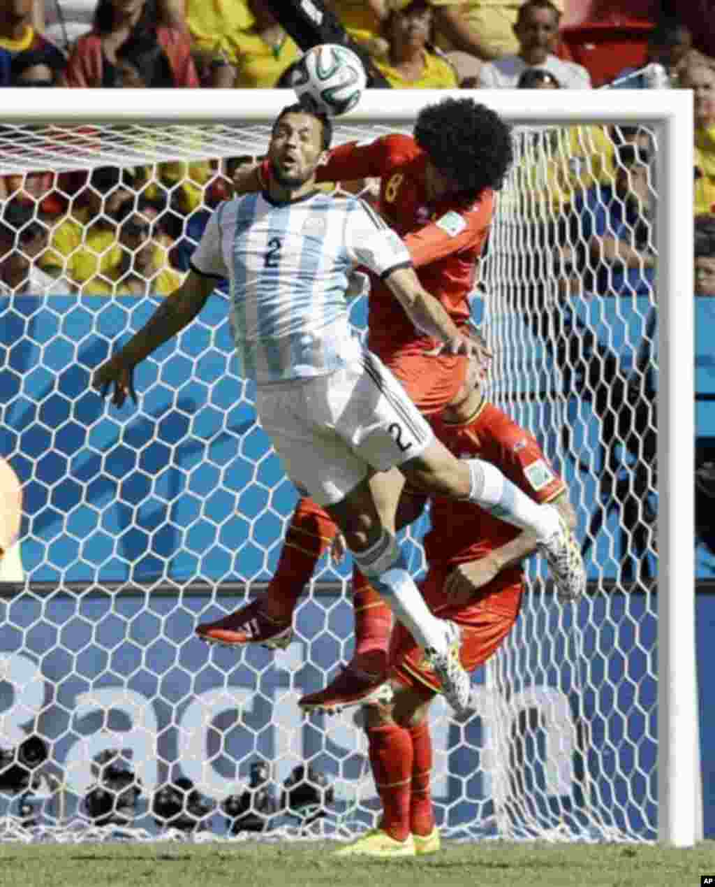 Argentina's Ezequiel Garay heads the ball away from Belgium's Marouane Fellaini in front of Argentina's goal during the World Cup quarterfinal soccer match at the Estadio Nacional in Brasilia, Brazil, Saturday, July 5, 2014. (AP Photo/Kirsty Wigglesworth)