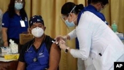 Seorang petugas kesehatan menyuntikkan vaksin Sinovac China pada seorang rekannya selama gelombang pertama vaksinasi di Pusat Paru Filipina di kota Quezon, Filipina pada hari Senin, 1 Maret 2021. (Foto: AP)