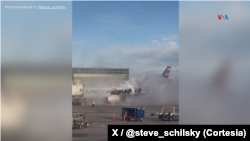 Pasajeros suben al ala de un avión de la compañía American Airlines para escapar de la aeronave, que se incendió en el aeropuerto de Denver, Colorado, el 13 de marzo de 2025. Foto de X: @steve_schilsky