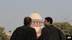 Supreme Court Lawyers speak to each other on the lawns of India's Supreme Court as it begins hearing dozens of petitions that seek revocation of a new citizenship law amendment in New Delhi, India, Jan. 22, 2020. 