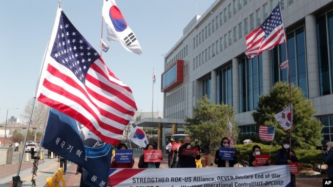 FILE - Demonstrators stage a rally welcoming the visit of U.S. Defense Secretary Lloyd Austin and Secretary of State Antony Blinken outside the Defense Ministry in Seoul, South Korea, March 17, 2021.