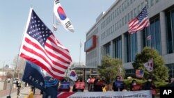 Protesters stage a rally welcoming the visit of US Defense Secretary Lloyd Austin and Secretary of State Antony Blinken outside the Defense Ministry in Seoul, South Korea, March 17, 2021. 