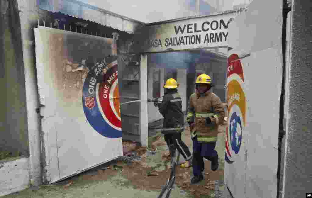 Firemen put out a fire in the Salvation Army Church after it was set on fire by rioting youths, Mombasa, Kenya, Oct. 4, 2013.
