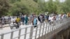 FILE - People cross a bridge linking Cameroon and Nigeria at Gamboru in Borno, Nigeria, Apr. 27, 2017.