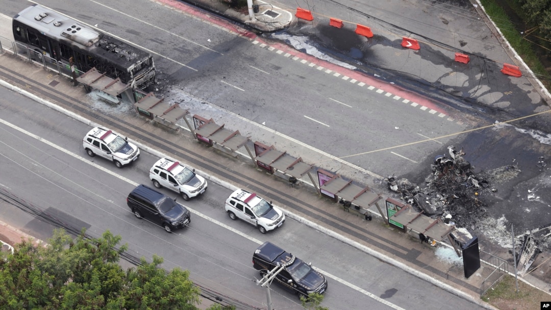 Lokasi jatuhnya pesawat kecil, kanan, yang membakar sebuah bus (kiri) di sebuah jalan raya di Sao Paulo, Jumat, 7 Februari 2025. (Foto: Ettore Chiereguini/AP Photo)