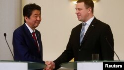 Estonian Prime Minister Juri Ratas shakes hands with Japanese Prime Minister Shinzo Abe, in Tallinn, Estonia, Jan. 12, 2018. 