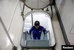 A female trainee climbs a ladder as she makes her way to a class aboard the Japanese helicopter carrier Kaga in the Indian Ocean, Indonesia, Sept. 23, 2018.