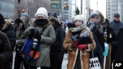 Photographers brave the cold to take pictures of guests arriving during Fashion Week in New York, Feb. 13, 2016.