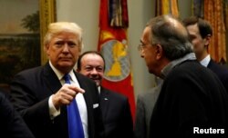 President Donald Trump greets Fiat Chrysler CEO Sergio Marchionne, right, as he hosts a meeting with U.S. auto industry CEOs at the White House in Washington, Jan. 24, 2017.