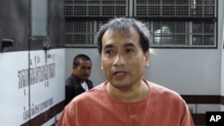 Thai-born American Joe Gordon gestures as he answers a reporter's question upon his arrival at a criminal court in Bangkok, Thailand, December 8, 2011.