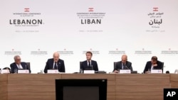 France's President Emmanuel Macron, center, flanked by Lebanese and French officials, chairs an international aid conference for Lebanon, in Paris, Oct.24, 2024.