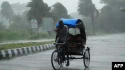 Rickshaw driver plows through heavy rain in Berhampur, about 180 kilometres south of Bhubaneswar, Oct. 12, 2013.