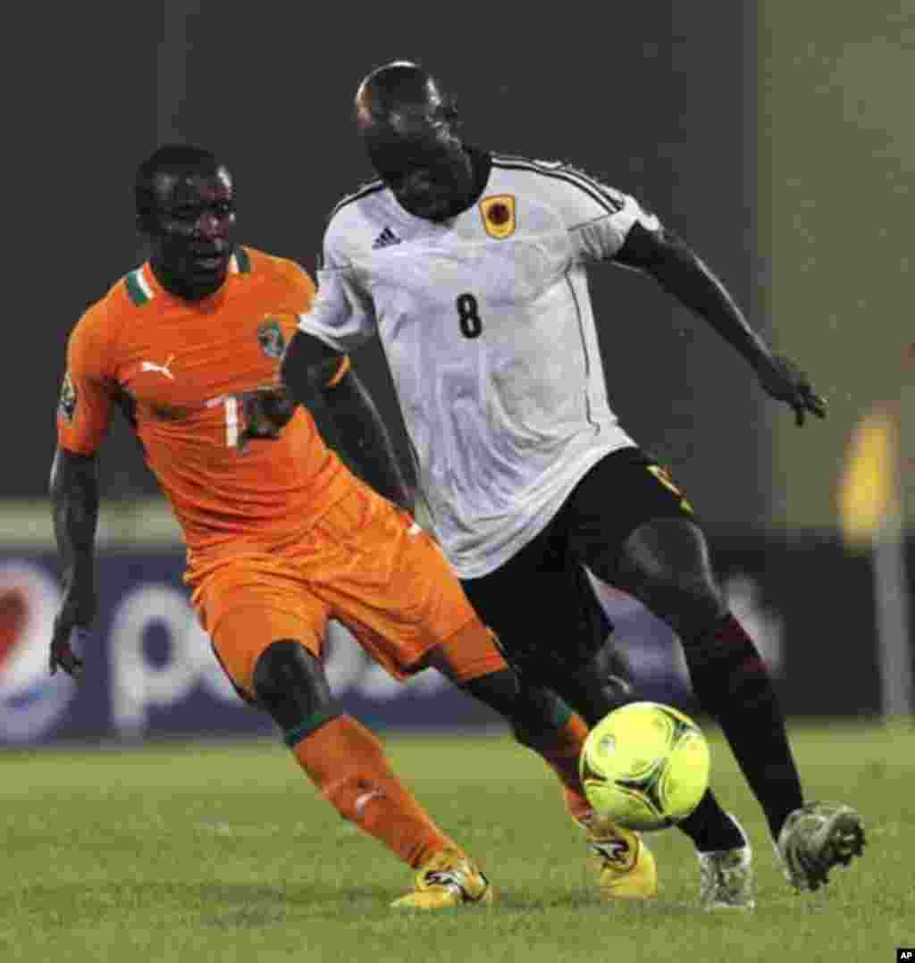 Seydou Doumbia (L) of Ivory Coast fights for the ball with Andre Macanga of Angola during their African Nations Cup soccer match in Malabo January 30, 2012.