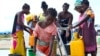 A young girl fetches water at a camp for displaced survivors of cyclone Idai in Beira, Mozambique, April, 2, 2019.