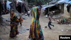 Rohingya Hindu refugees walk through the Kutupalong Hindu refugee camp near Cox's Bazar, Bangladesh, Dec. 17, 2017.