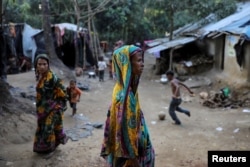 Rohingya Hindu refugees walk through the Kutupalong Hindu refugee camp near Cox's Bazar, Bangladesh, Dec. 17, 2017.