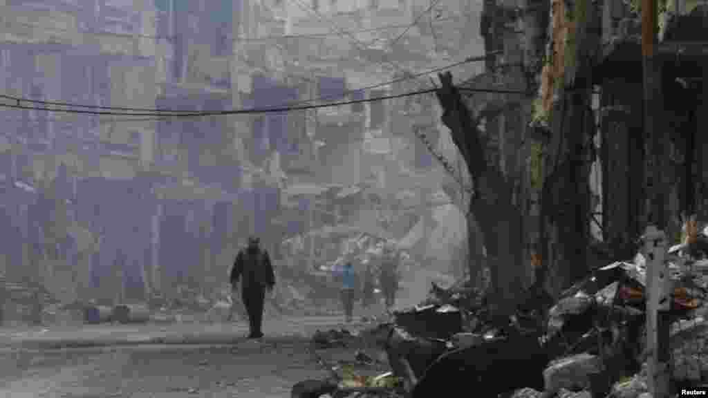 A man walks along a damaged street in Deir al-Zor, Nov. 27, 2013. 