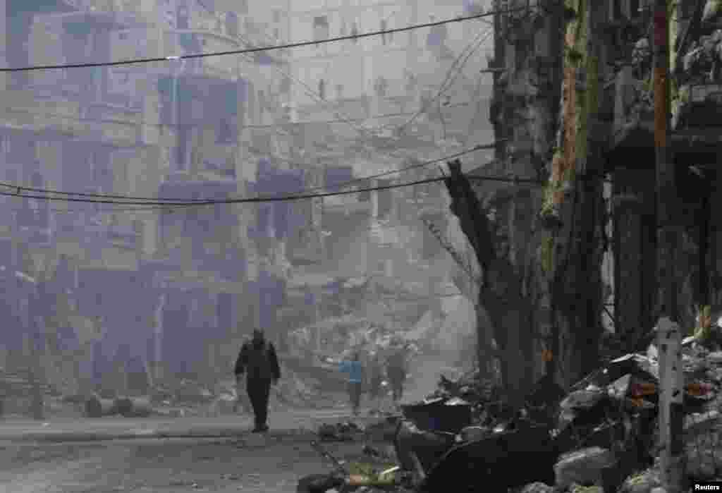A man walks along a damaged street in Deir al-Zor, Nov. 27, 2013. 