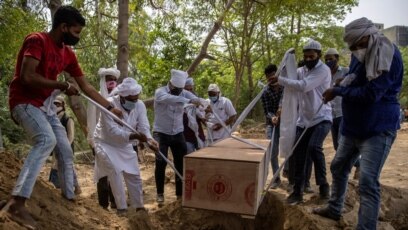 Một số người chôn cất thi thể của một người đàn ông chết vì COVID-19 tại một nghĩa trang ở New Delhi, Ấn Độ, ngày 16 tháng 4, 2021.