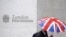 Seorang pekerja berlindung di bawah payung dengan motif bendera Inggris (Union Flag) saat melewati Bursa Efek London di London, Inggris, 1 Oktober 2008. (REUTERS/Toby Melville)