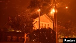 미 캘리포니아주 포터랜치 산불 현장 인접 주민이 지난 11일 강풍에 집으로 날리는 불꽃과 다투고 있다. 