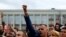 A man raises his fist as he attends an opposition demonstration to protest against presidential election results at the Independence Square in Minsk, Belarus, Aug. 25, 2020. 