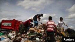 FILE - Venezuela migrants are seen at a garbage dump in the border city of Pacaraima, Brazil, April 15, 2019. 