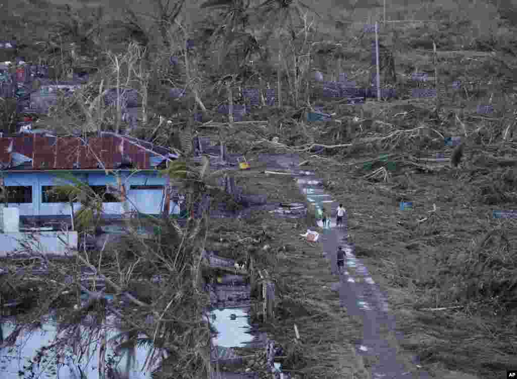 Residents go on their daily business Nov. 9, 2013, following a powerful typhoon that hit Tacloban city, in Leyte province, central Philippines.