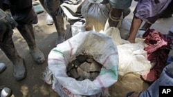 Men stand around a bag filled with Cassiterite, a tin product, on the outskirts of Walikale, Congo (2010 file photo)