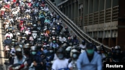 台北街頭早高峰時間戴著口罩騎車的市民。（2021年7月13日）
