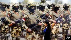 A visitor walks past a banner displaying Egyptian commandos during the first arms fair organized in Cairo, Egypt, Dec. 3, 2018. Egypt's President Abdel-Fattah el-Sissi inaugurated the fair, where hundreds of companies are participating.